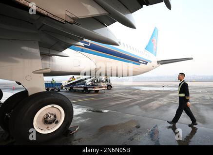 (230210) -- DALIAN, Feb. 10, 2023 (Xinhua) -- Ma Baoli patrols around the airplane before takeoff in Dalian, northeast China's Liaoning Province, Feb. 4, 2023. Captain Ma Baoli, 35, has a great passion for Chinese classical poems. From 2018 onwards, Ma has been participating in the Chinese Classical Poetry Quiz Show every year, and won the championship this year.Ma's love for Chinese classical poems was nurtured by his father since childhood. As a graduate of Nanjing University of Aeronautics and Astronautics, Ma joined the Dalian branch of China Southern Airlines and was promoted to captain i Stock Photo