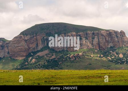 rock strata or layers showing clearly closeup on typical Drakensberg mountain or hill landscape which is green in Summer Stock Photo