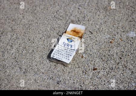Hope (ホープ) cigarette pack, on the ground, discoloured; Japan Stock Photo