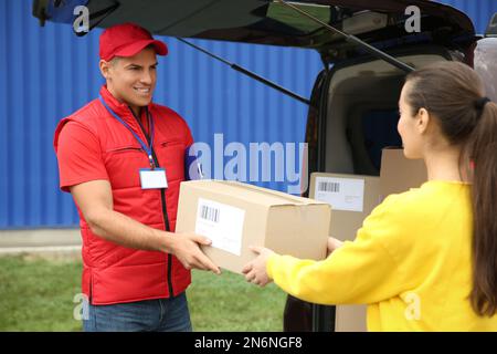 Courier giving package to customer on street Stock Photo