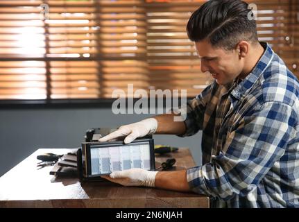 Professional repairman fixing modern printer in office Stock Photo