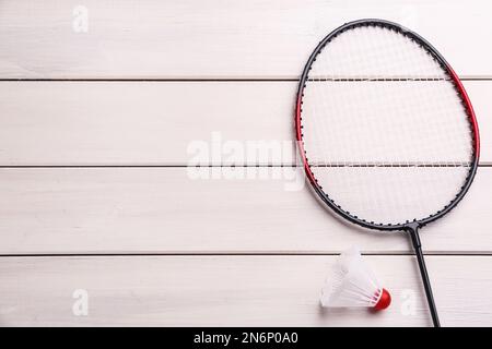 Badminton racket and shuttlecock on white wooden table, flat lay. Space for text Stock Photo