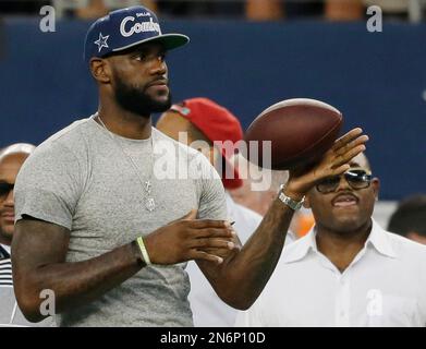 LeBron James tosses the football before the beginning of the game