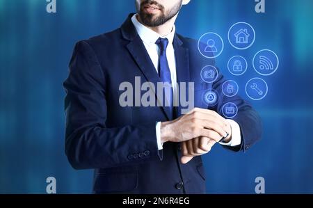 Businessman with modern smartwatch on blue background Stock Photo
