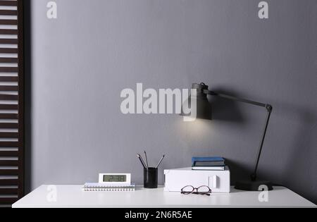 Lamp and different stationery on table in office. Space for text Stock Photo