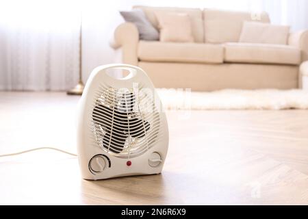 Modern electric fan heater on floor at home Stock Photo