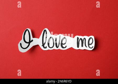 Piece of paper with handwritten phrase I Love Me on red background, top view Stock Photo