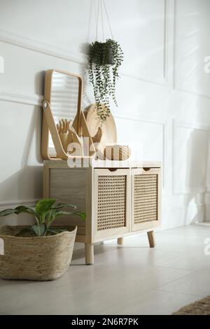 Wooden commode near white wall in room. Interior design Stock Photo