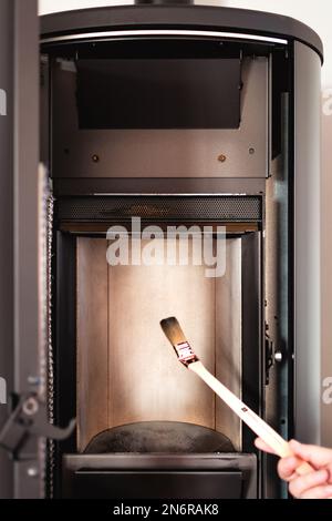 Man cleaning pellet stove with brush Stock Photo