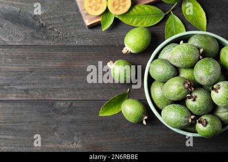Flat lay composition with fresh green feijoa fruits on black wooden table, space for text Stock Photo