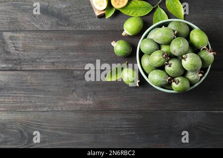 Flat lay composition with fresh green feijoa fruits on black wooden table, space for text Stock Photo