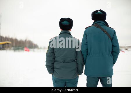 Two rescue workers. Men in uniform. Warm lifeguard uniform in Russia. Two employees guys. Stock Photo