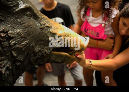 People rubbing and inserting coins in a bronze boar in Florence Italy Stock Photo