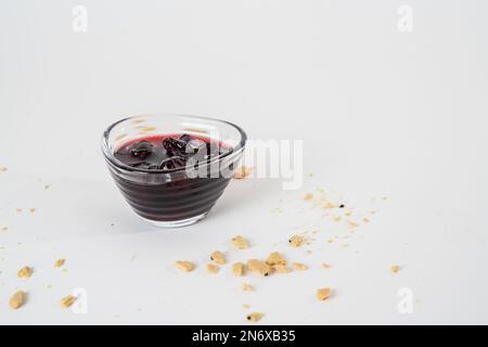 Homemade sour cherry jam, jar and small bowl with jam isolated on white background. Stock Photo