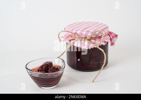 Homemade strawberry jam, jar and small bowl with jam isolated on white background. Stock Photo