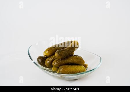 Top view of pickled gherkins on glass plate isolated on white background. Stock Photo