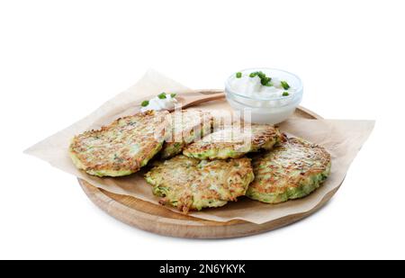 Delicious zucchini fritters with sour cream on white background Stock Photo