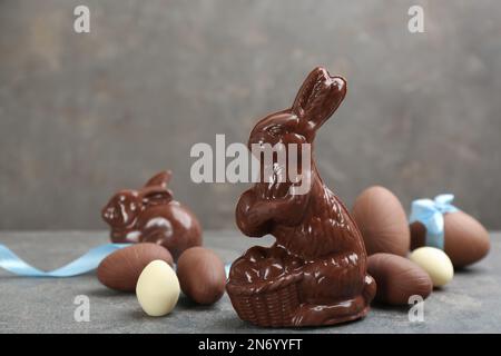 Chocolate Easter bunny and eggs on grey table. Space for text Stock Photo