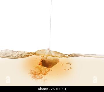 Dipping of tea bag into hot water against white background Stock Photo