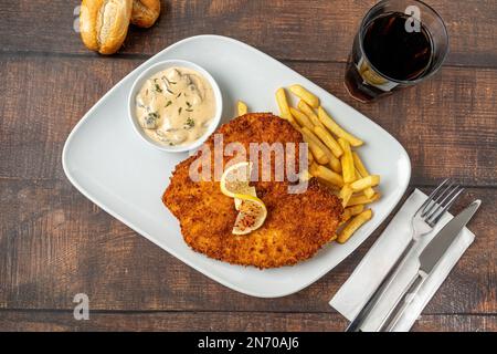 Chicken schnitzel with butter and potato salad on white porcelain plate Stock Photo