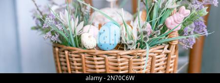 Russia, Moscow, 04.09.2022. happy easter holiday time in spring season. basket with painted eggs, easter baked cakes, flowers plants, and sweet rabbit Stock Photo