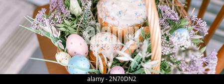 Russia, Moscow, 04.09.2022. happy easter holiday time in spring season. basket with painted eggs, easter baked cakes, flowers plants, and sweet rabbit Stock Photo
