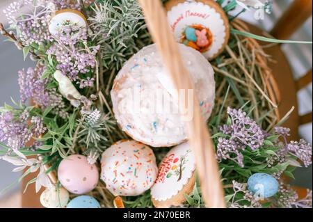 Russia, Moscow, 04.09.2022. happy easter holiday time in spring season. basket with painted eggs, easter baked cakes, flowers and plants, and sweet ra Stock Photo