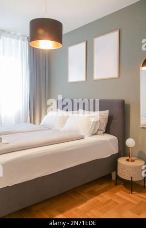King size bed in simple and cozy bedroom. Stock Photo