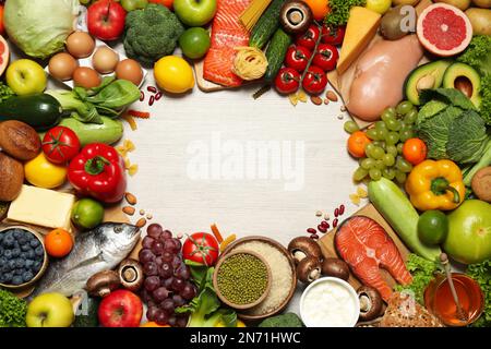 Frame of different food products on wooden table, flat lay with space for text. Healthy balanced diet Stock Photo