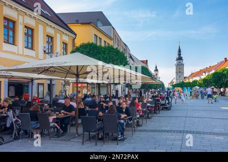 Trnava (Tyrnau), pedestrian zone street Hlavna, Town hall tower, restaurant in Slovakia Stock Photo