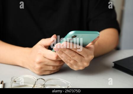 MYKOLAIV, UKRAINE - JULY 9, 2020: Woman holding Iphone 11 Green at table, closeup Stock Photo