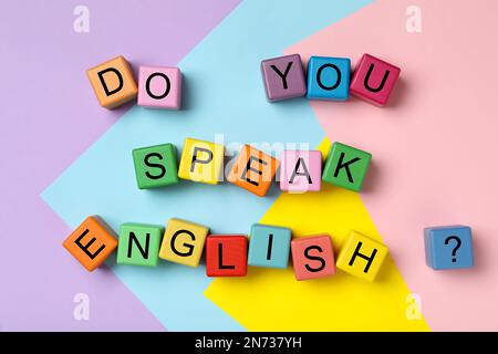 Cubes with question Do You Speak English on color background, flat lay Stock Photo