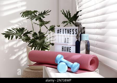 Premium Photo  Sport equipment and lightbox with hashtag fitness at home  on floor indoors message to promote selfisolation during covid19 pandemic