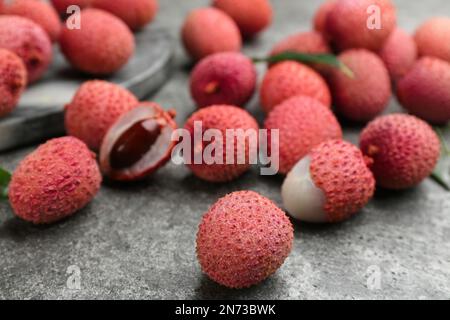 Fresh ripe lychee fruits on grey table, closeup Stock Photo