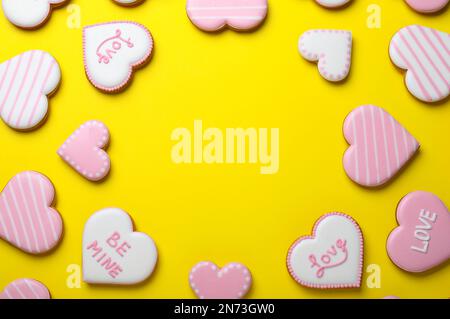 Frame made of cookies on yellow background, flat lay with space for text. Valentine's day treat Stock Photo