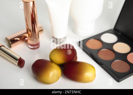 Fresh ripe palm oil fruits and cosmetic products on white background, closeup Stock Photo