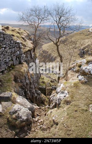 Head of Conistone Dib. The footpath to Conistone follows the wall down a narrow valley cut into Hill Castles Scar before entering the flat valley of C Stock Photo