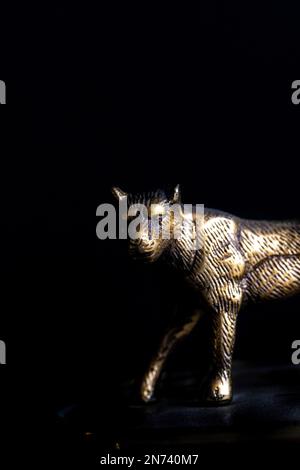 Bronze statue of golden panther against black background Stock Photo