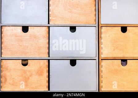 front view of closed wooden painted drawers for storing small items in rack Stock Photo