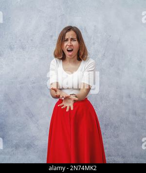 Portrait of offended young girl in a red skirt Stock Photo