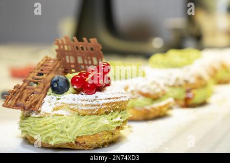 Paris Brest, a classic French dessert consist of large baked ring of choux pastry, filled with soft Pistachio and hazelnut cream topped with roasted P Stock Photo