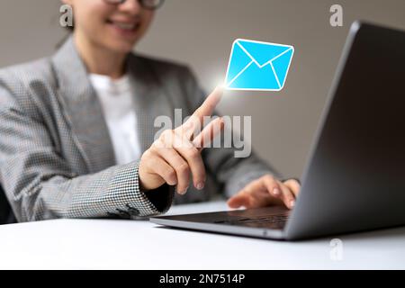 Young businesswoman opening virtual email with touching her finger to digital mail envelope. Stock Photo