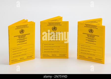 Three new international vaccination cards, yellow, white background, Stock Photo