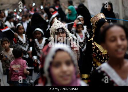 Yemeni girls wearing traditional costumes, attend a festival for