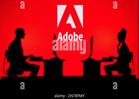LOS ANGELES, USA, JANUARY 30, 2023: Adobe. Collaboration Leads to Progress: Two Developers Working Together Under the Company's Logo Stock Photo