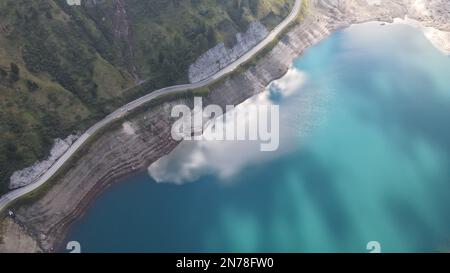 An aerial top view of Lake Fedaia reflecting the clouds in the Dolomites range of northeastern Italy Stock Photo