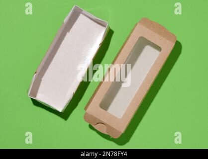 Rectangular cardboard box with a transparent plastic lid on a green background, top view Stock Photo
