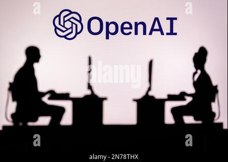 LOS ANGELES, USA, JANUARY 30, 2023: Open AI. A Glimpse into the Tech World: Silhouette of Software Developers with Company Logo Behind Them Stock Photo