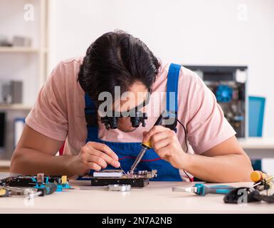 Young male contractor repairing computer Stock Photo