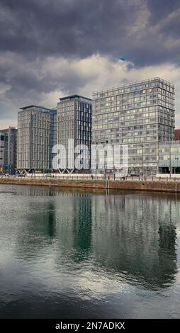 Modern buildings that make up Liverpool's waterfront. Taken from the Albert Dock looking down river towards the Liver Building. Stock Photo
